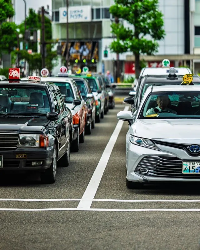 chaos can only thrive in the absence of order. taxi drivers line up neatly while waiting on new passengers.