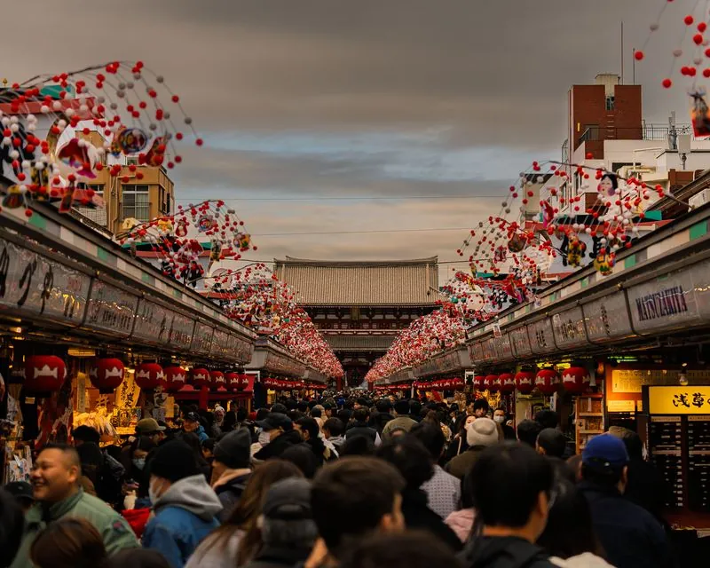red and white balloons arch over the crowd toward the temple gate