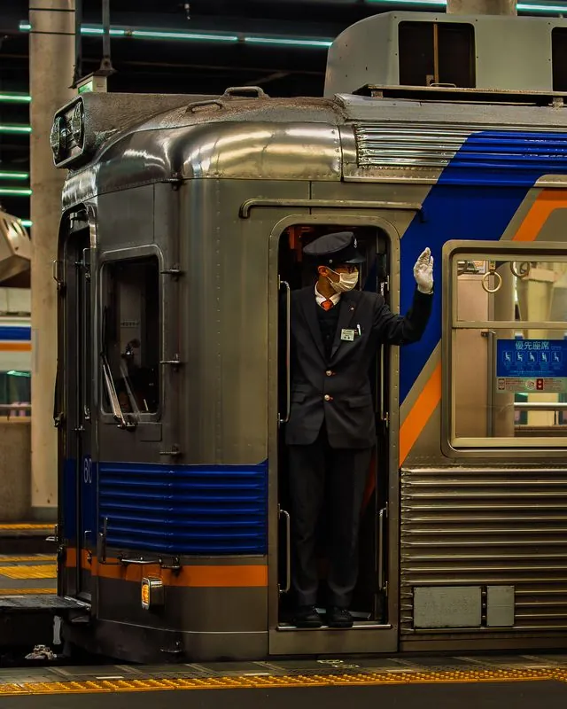 the conductor salutes from the doorway, white gloves, masked, ritual at every stop